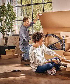 Mondi Bike Packaging Solutions'ın ürettiği bir bisikleti kutudan çıkaran bir adam ve bir çocuk