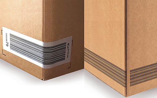 İki oluklu kutu: birinde barkod etiketi yapıştırılmış, diğerinde ise barkod basılmış.