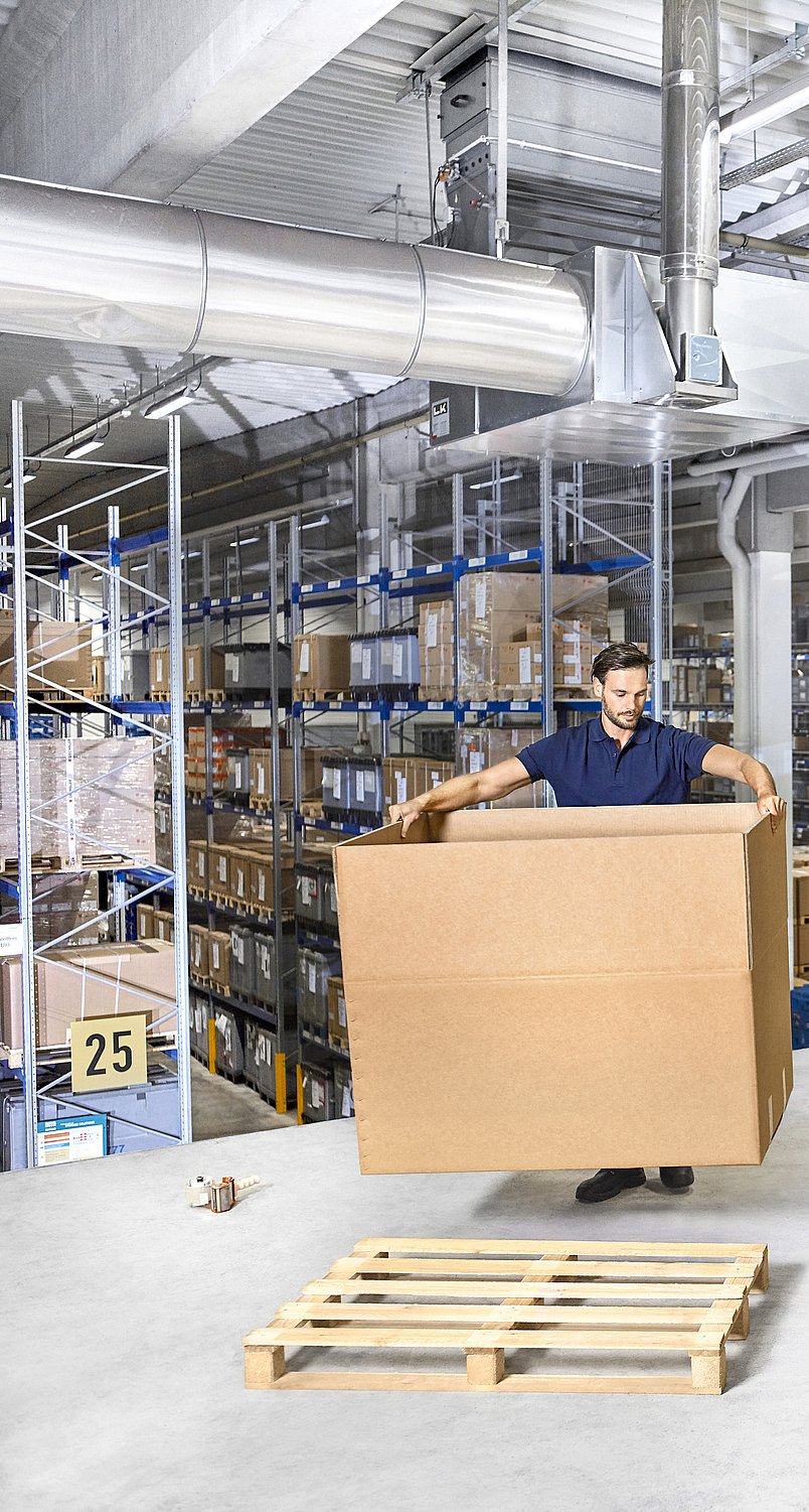 Ağır yükler için oluklu mukavva kutu monte eden bir kişi.