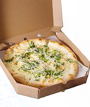 Kahverengi oluklu kutu içerisinde pizza.